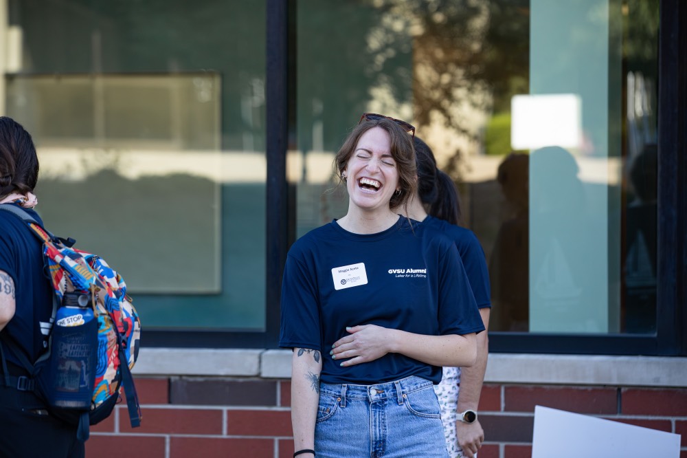 GVSU Alumna laughs with hand over stomach